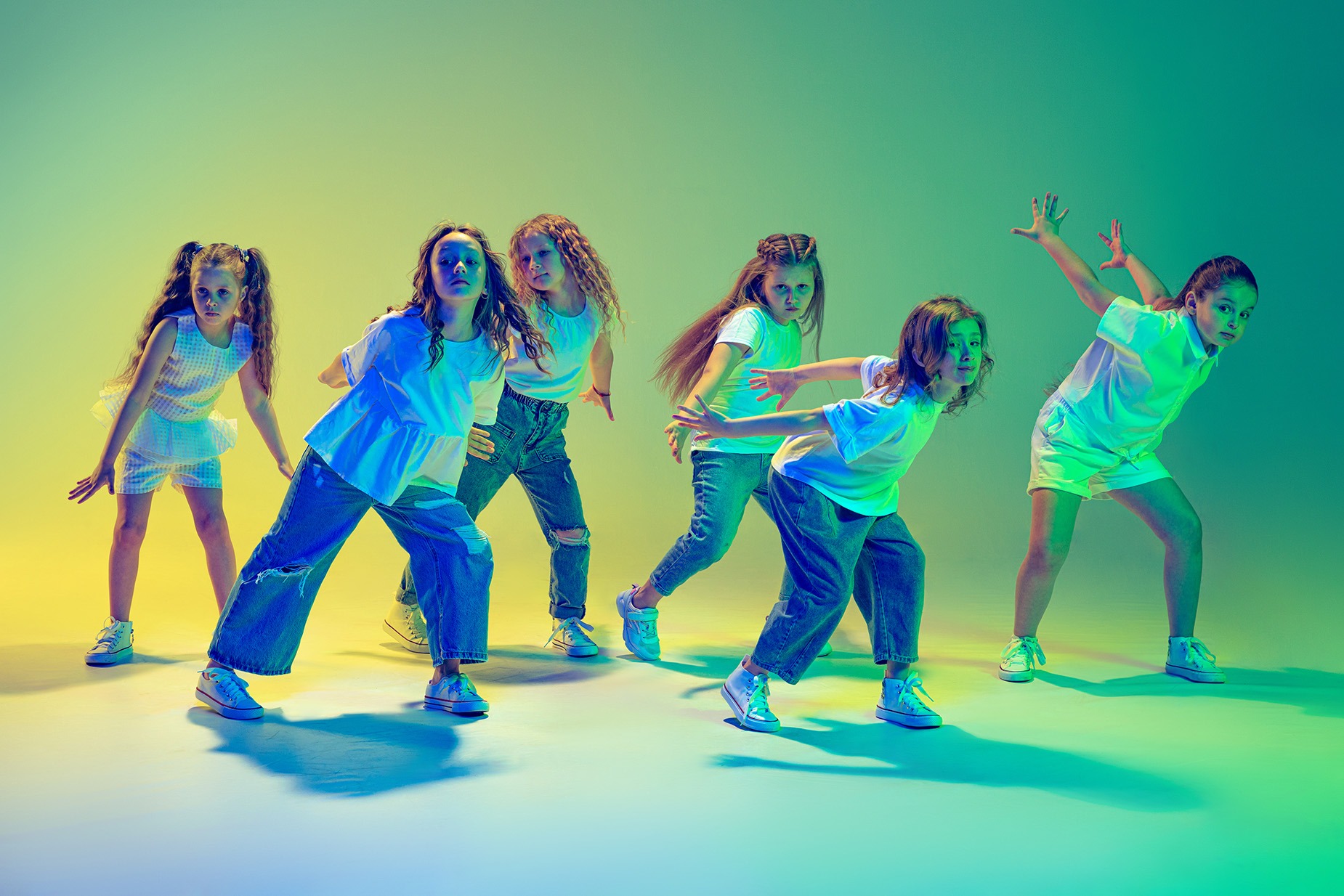 Eine Gruppe junger Tänzerinnen performt in professionellem Bühnenlicht während einer Schulproduktion von groove2grow.