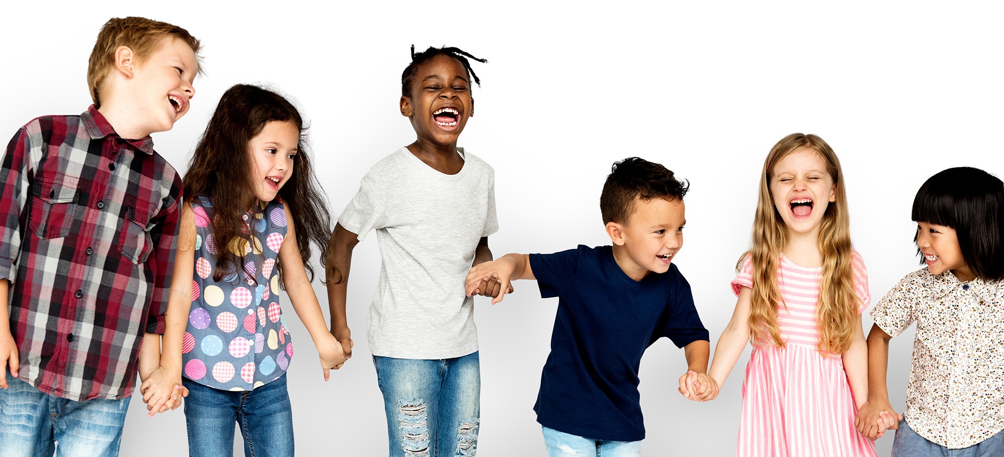Eine diverse Gruppe von sechs glücklichen Kindern hält sich an den Händen, lacht und bewegt sich gemeinsam vor einem weißen Hintergrund – Symbol für soziale Bindung durch Bewegung.