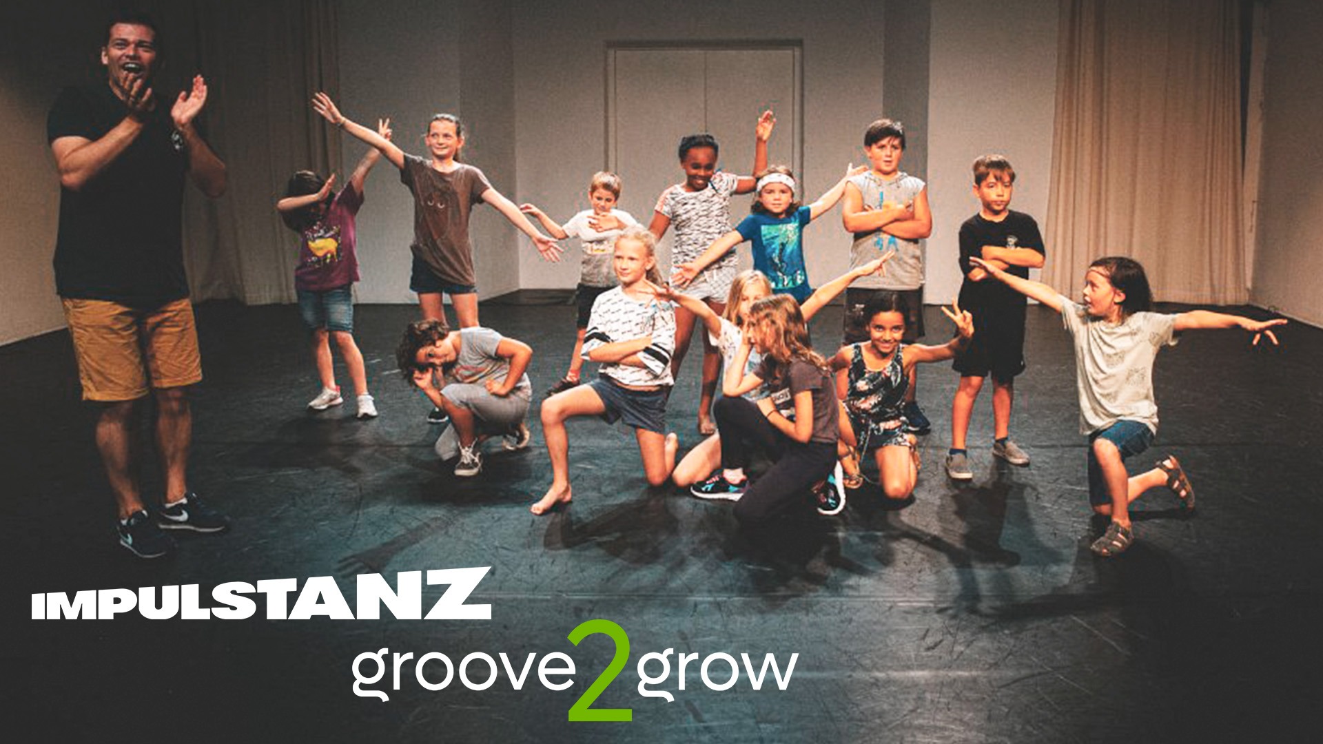 Gruppe Kinder auf Bühne bei groove2grow Projekt – gemeinsames Tanzfinale mit stolzen Gesichtern.