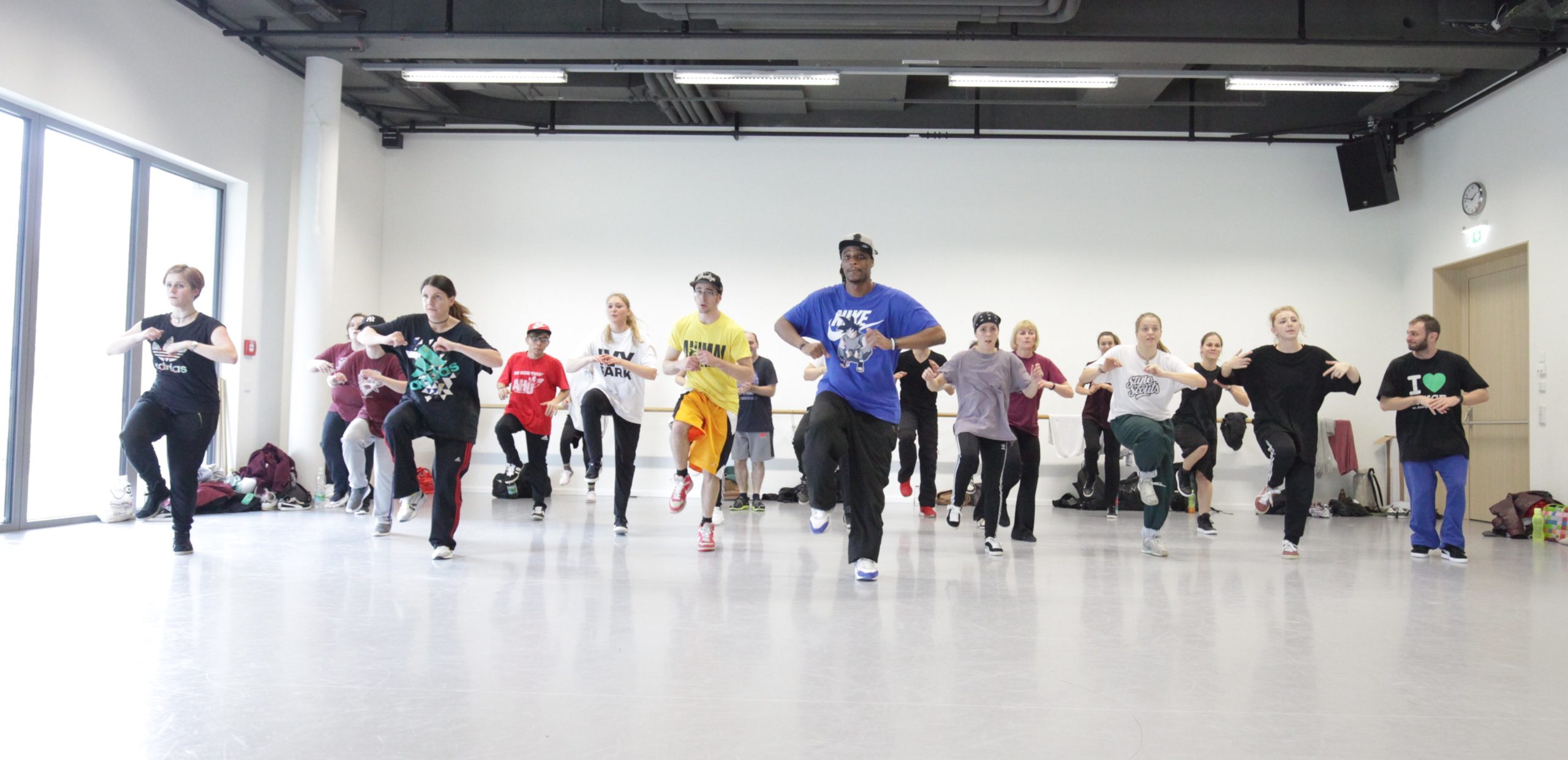 Eine Gruppe übt Hip-Hop-Schritte gemeinsam im Tanzstudio