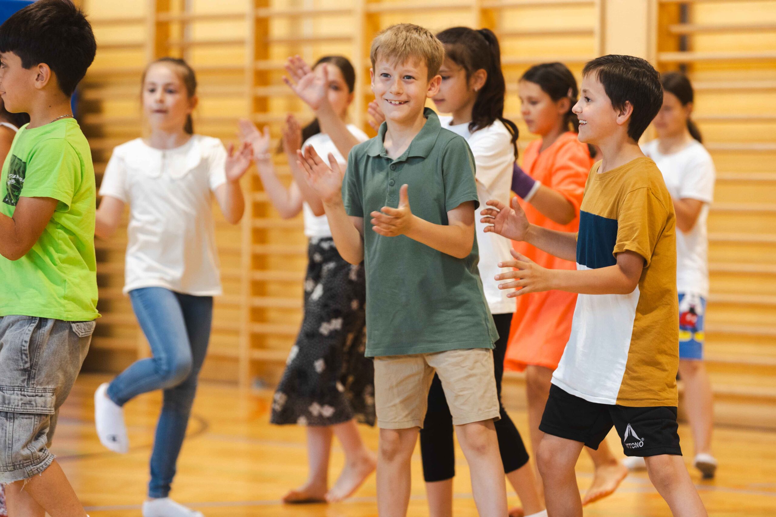 Lachende Schüler beim gemeinsamen Tanzen und Klatschen im Rahmen des groove2grow Projekts in Wels.