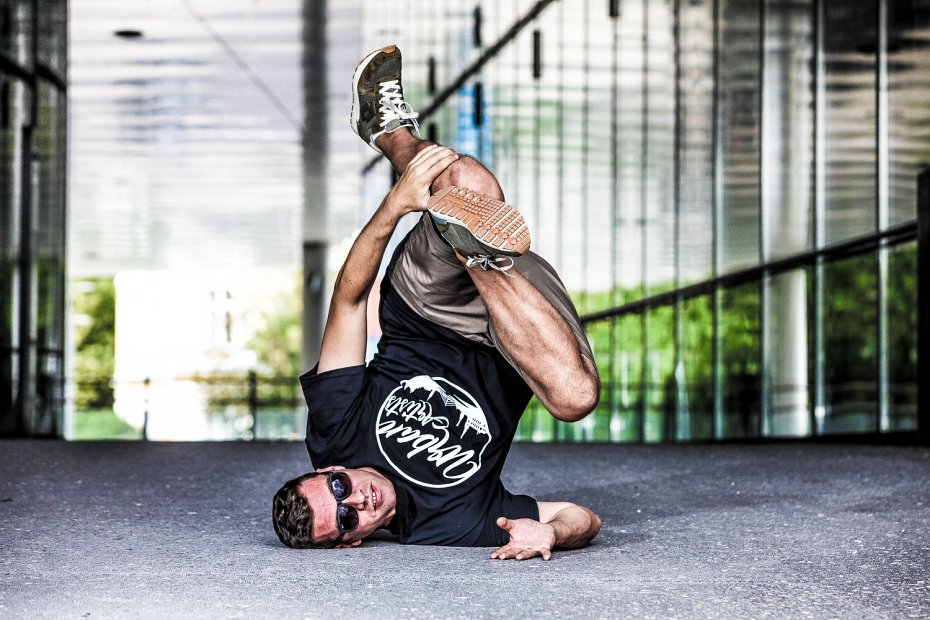 Markus Eggensperger zeigt akrobatische Breakdance-Figur auf dem Schulhof – urbaner Tanzstil als Teil moderner Bewegungskultur im Schulunterricht.